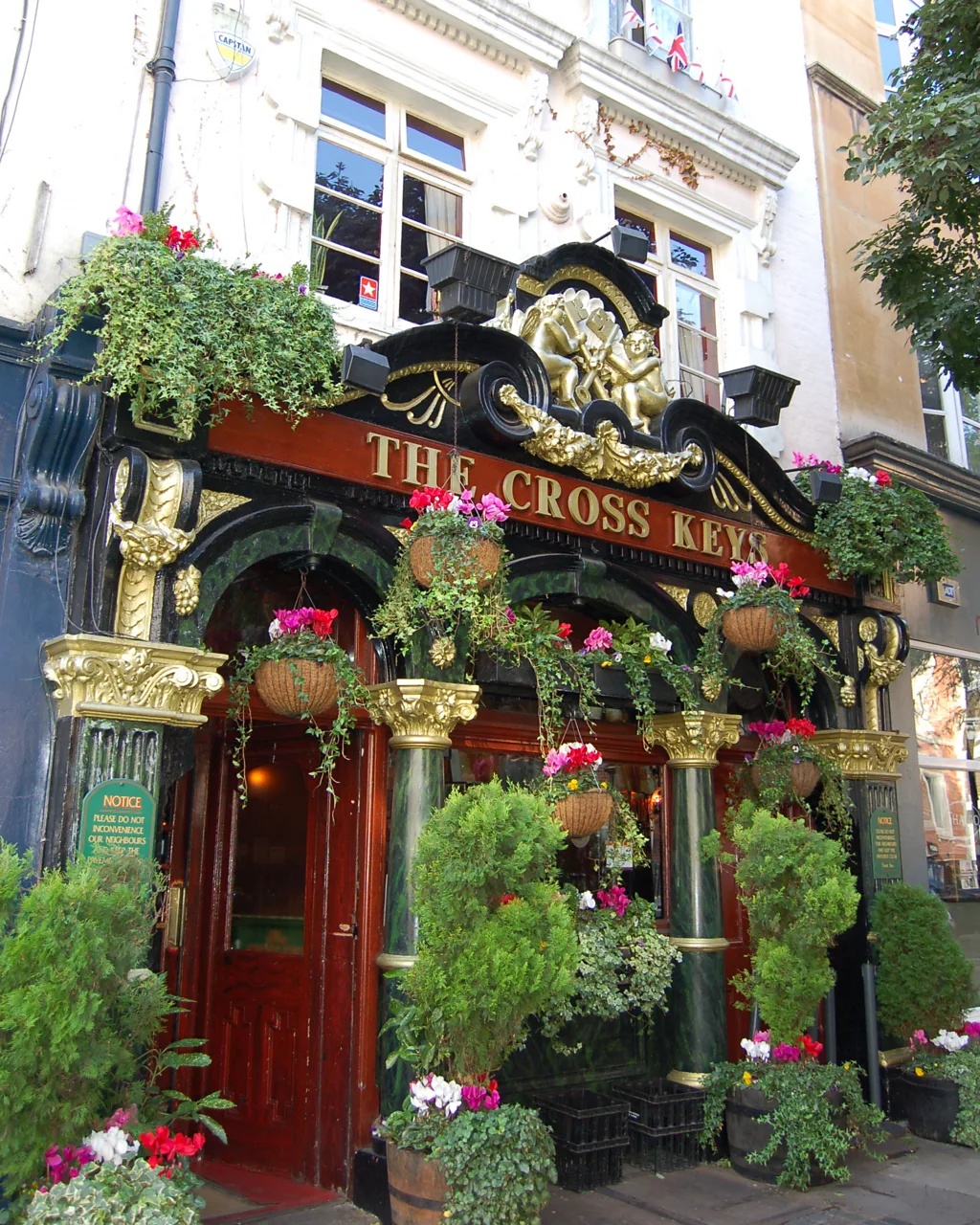 The interior of The Mayflower, a historic pub in London. The image captures the pub's charming and rustic atmosphere, with wooden beams, vintage decor, and cozy seating areas. Patrons are seen enjoying their drinks and meals, creating a lively and welcoming ambiance that reflects the rich history of this iconic establishment.